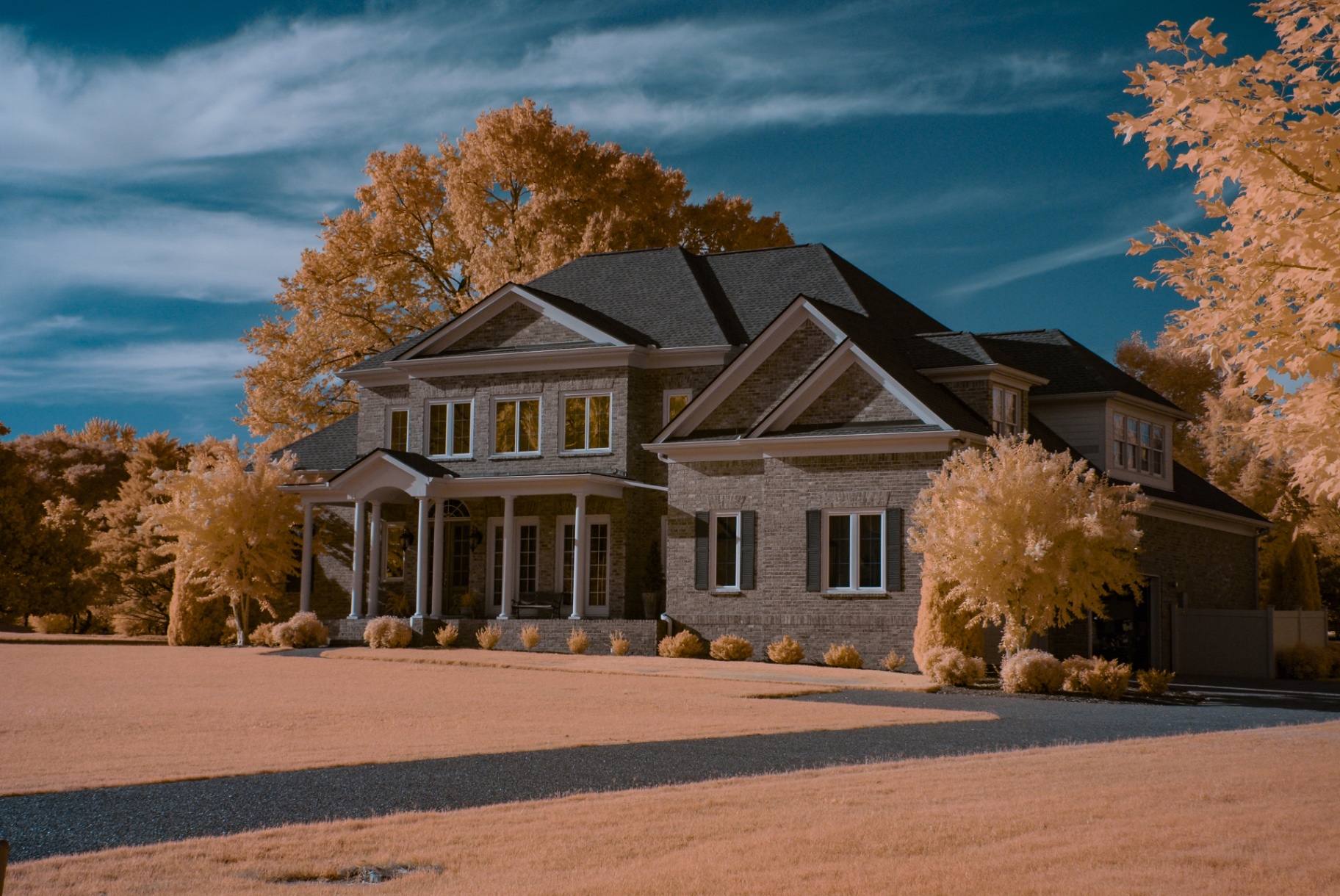 Brick estate home framed by glowing golden infrared foliage in SummerHill, Franklin, Tennessee — Nikon D200, 590nm, 18-140mm DX kit lens